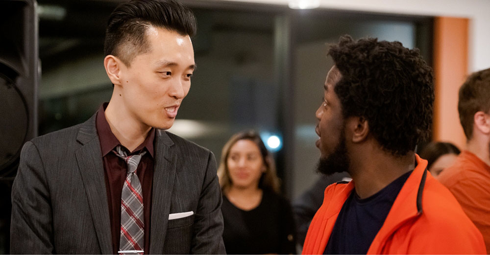 Two professional men having a conversation at an event