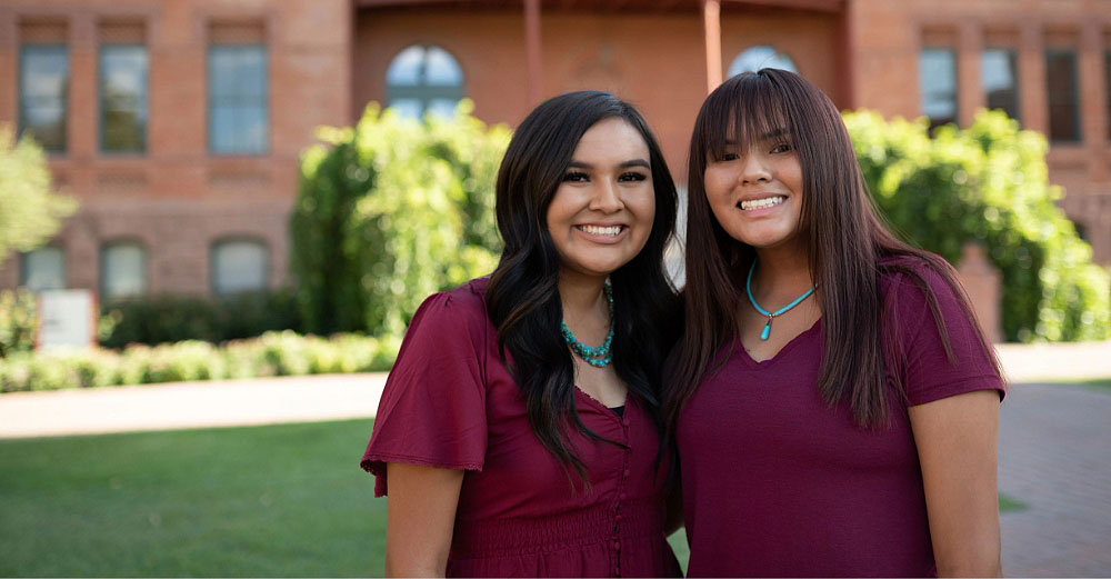 Two young women smiling outside Old Main at ASU