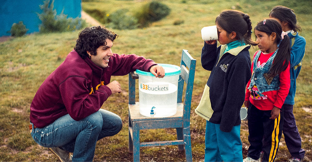 Man gives clean water to young children