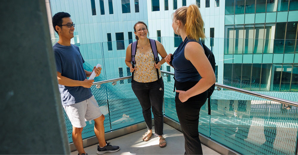 Three students having a conversation inside a school building 