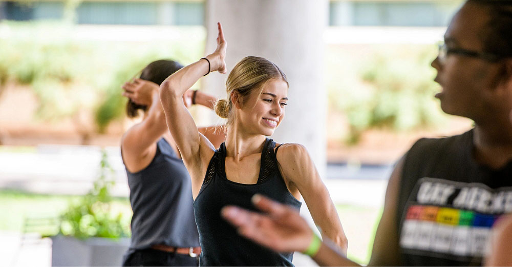 Female student striking a pose at a group dance class