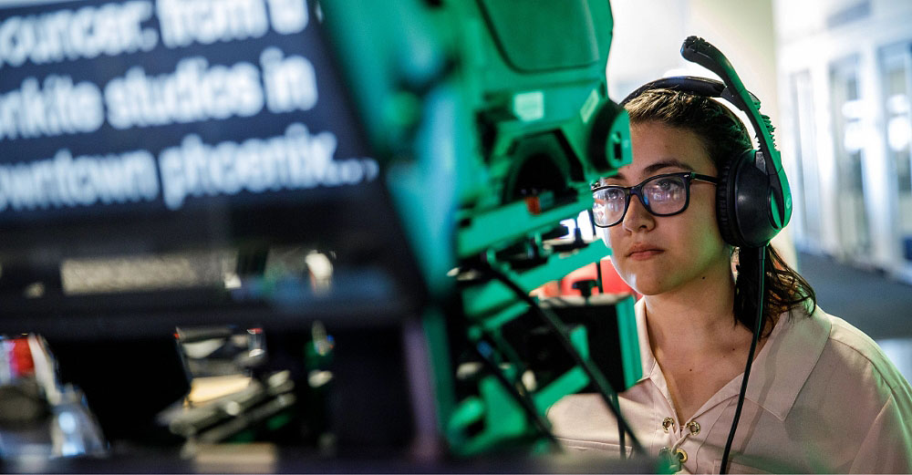 Female student working teleprompter with headset on