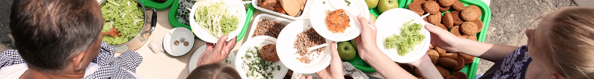 A group of people putting food onto plates