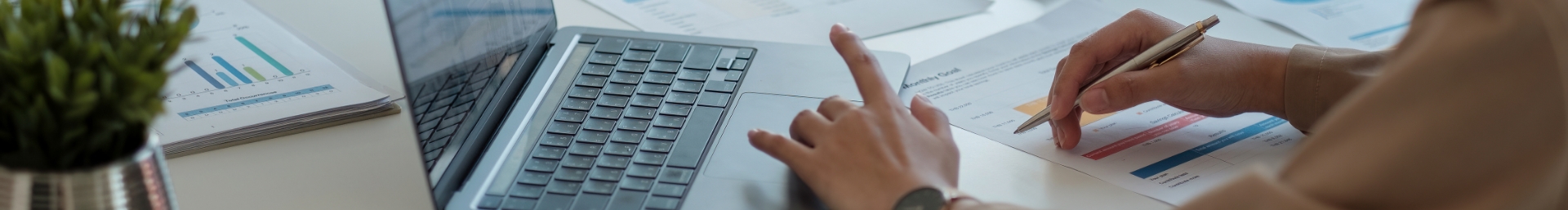 Hands using a computer and holding a pen